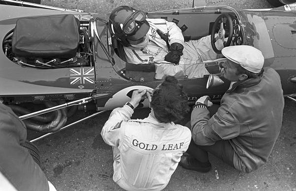 Graham Hill im Cockpit des Lotus 49B Jackie Oliver links und Colin Chapman